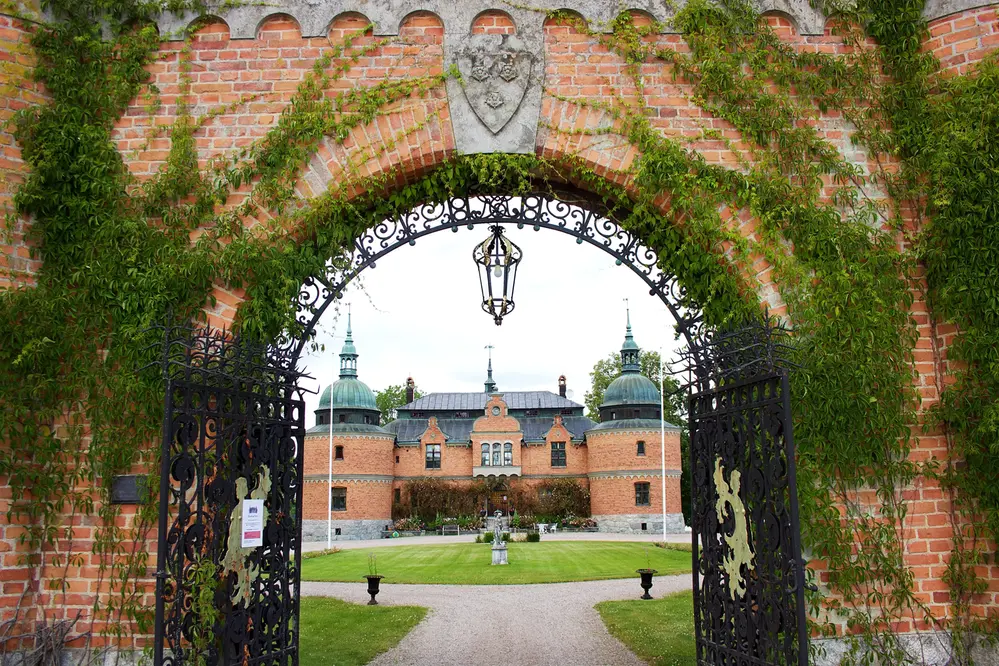 ett slott i bakgrunden och en järngrind som leder in till slottet